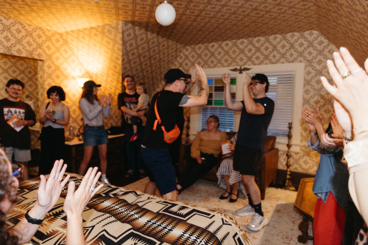 Guests raising their hands during a group moment at Anti-Networking Denver