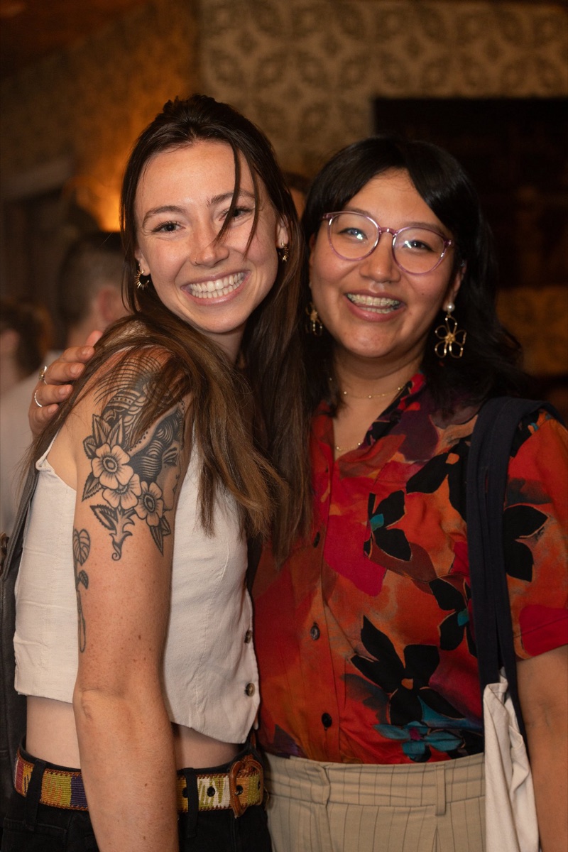 Two friends arm in arm at Anti-Networking Denver